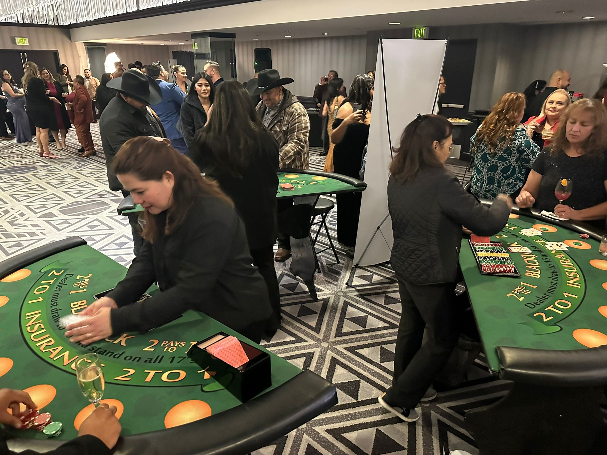 Invités et croupiers autour des tables de blackjack lors d’une soirée LEYGACY