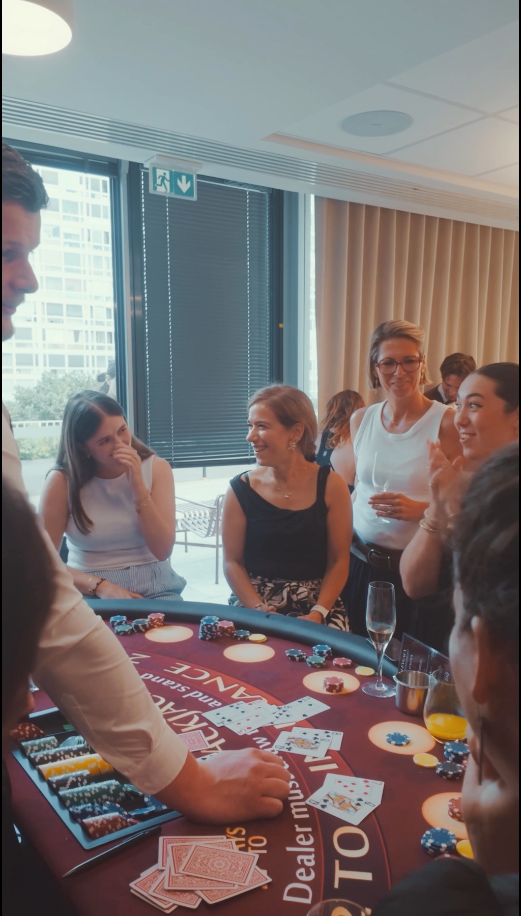 Groupe d’invités applaudissant autour de la table de blackjack, coupes de champagne à la main