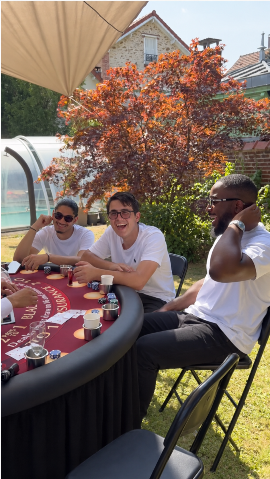 Invités hilares autour de la table de blackjack, en terrasse au soleil